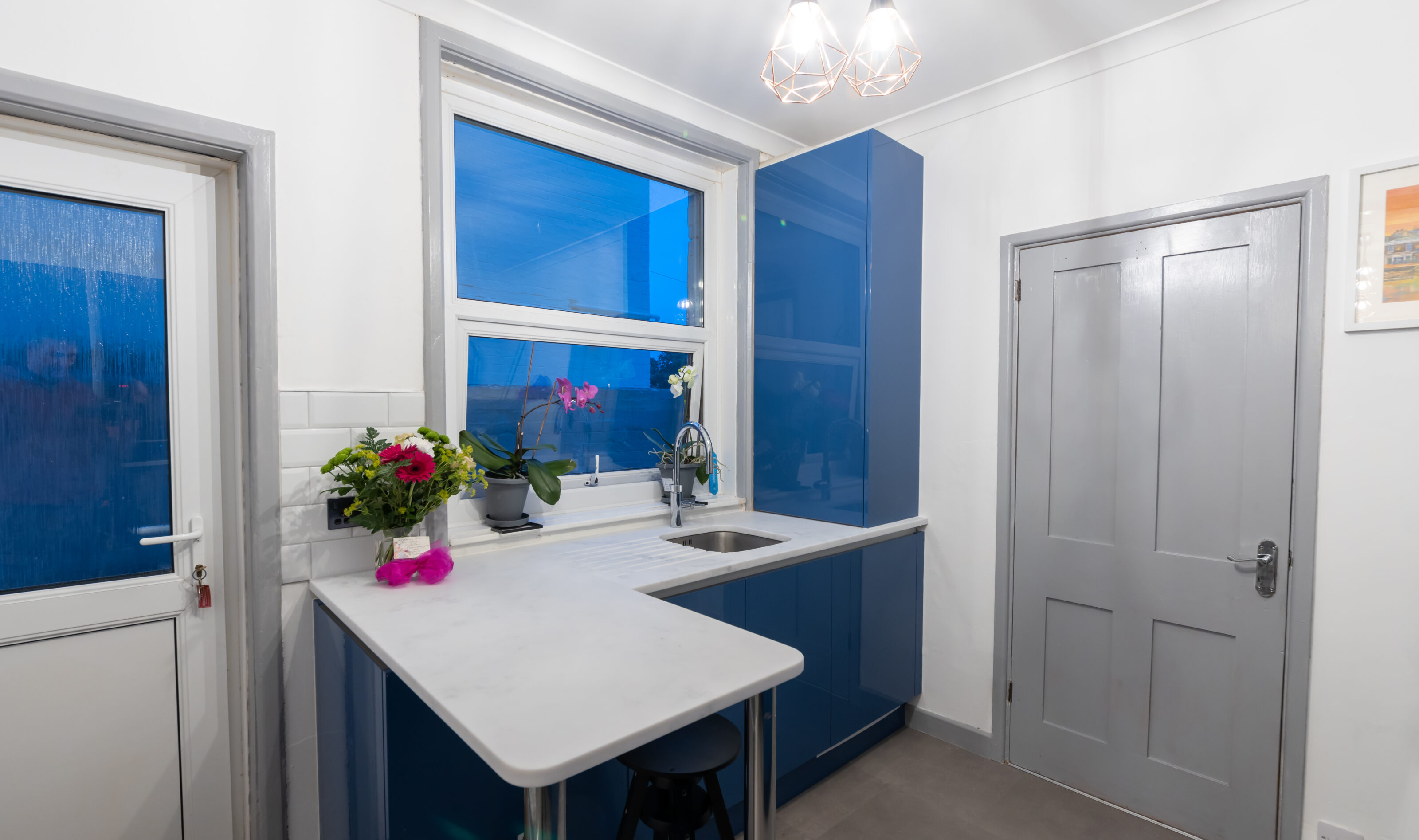 stainless steel sink in gloss blue kitchen