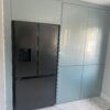 metallic blue kitchen cupboards with American fridge