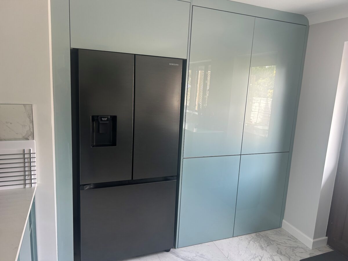 metallic blue kitchen cupboards with American fridge