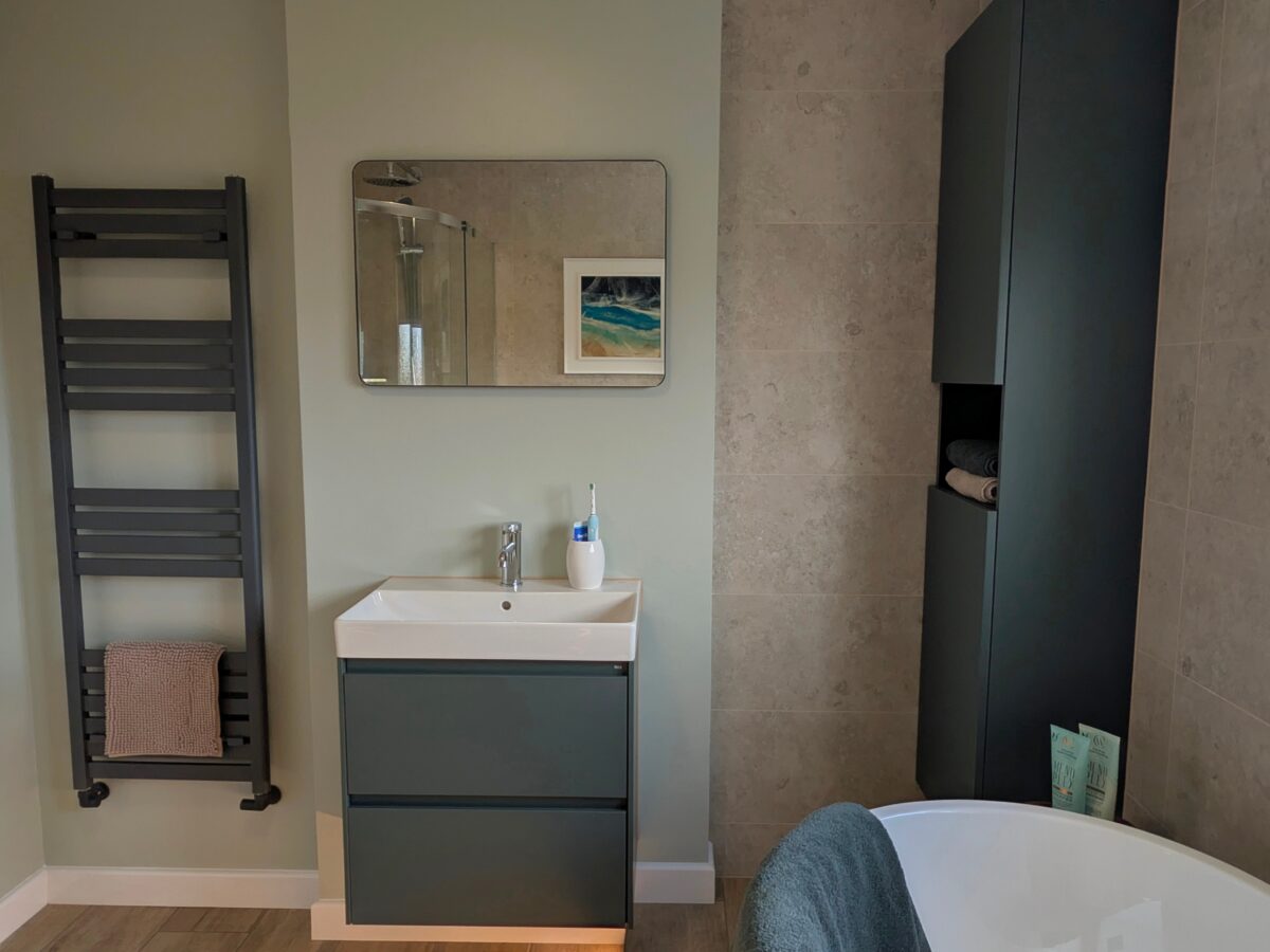 neutral bathroom with green bathroom furniture
