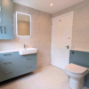 neutral bathroom with grey fossil perla tiles and blue accents